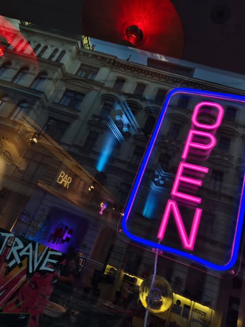 Akira-Foto vom Instagram-Auftritt mit leuchtendem OPEN-Schild